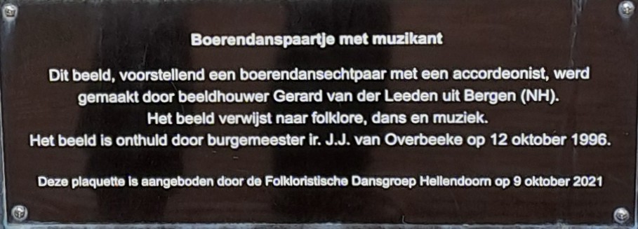 Bauerntanzpaar mit Musiker - Diese Skulptur, die ein bäuerliches Tanzpaar mit einem Akkordeonspieler darstellt, wurde vom      Bildhauer Gerard van der Leeden aus Bergen (Nordholland) geschaffen.
                         Die Skulptur verweist auf Folklore, Tanz und Musik.
                         Sie wurde am 12. Oktober 1996 vom Bürgermeister Ing. J. J. van Overbeeke feierlich enthüllt.
                         Diese Gedenktafel wurde von der Folkloristischen Tanzgruppe Hellendoorn am 9. Oktober 2021 gestiftet.